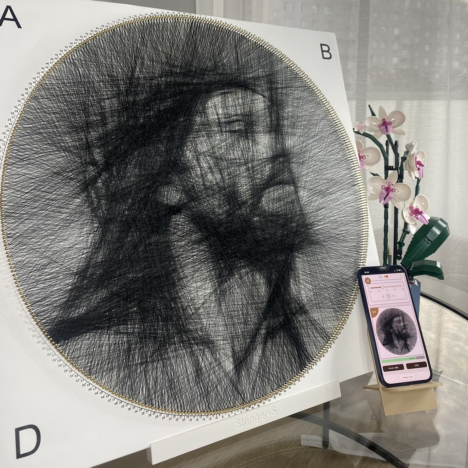 Finished artwork made with the square String Art kit and phone stand